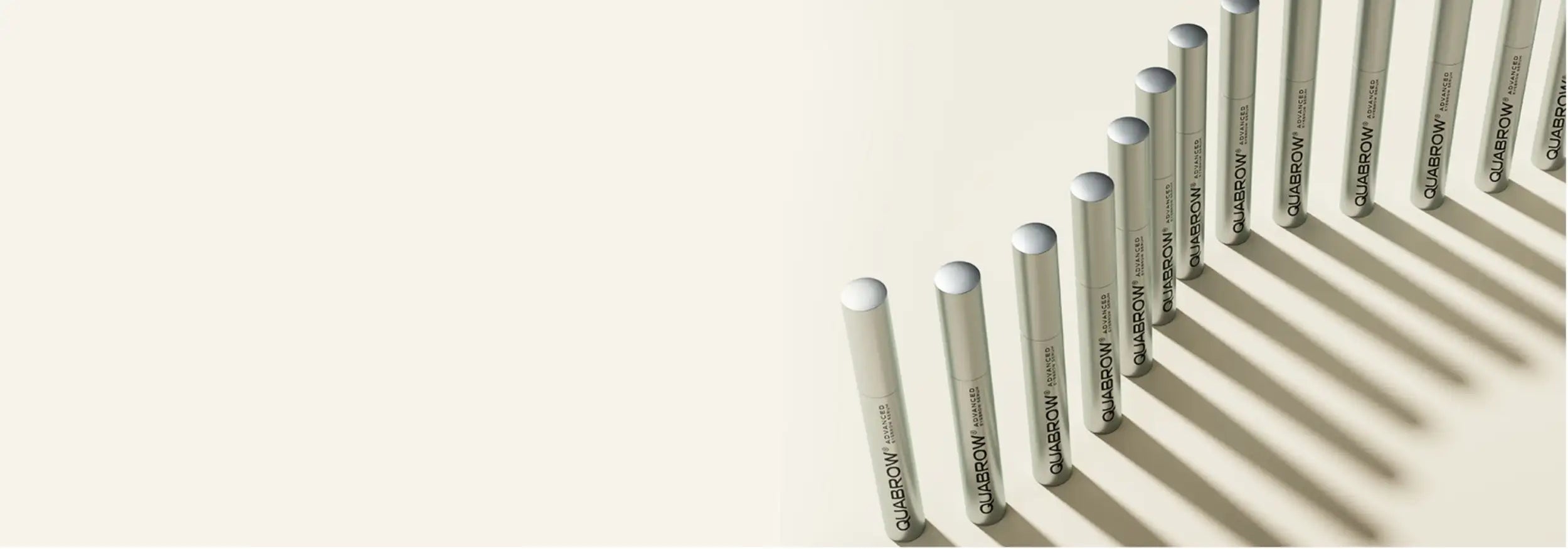 Silver cylindrical tubes of quilason hair care product, arranged in a diagonal line.